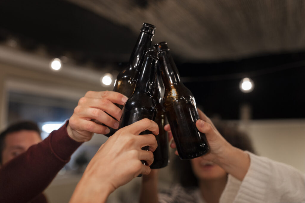 Descubriendo el Arte de la Cata de Cerveza Artesanal | vista lateral personas sosteniendo botellas Cata cerveza en Denia